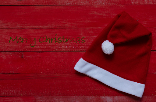 Santa Claus hat on wooden background, holiday Christmas concept