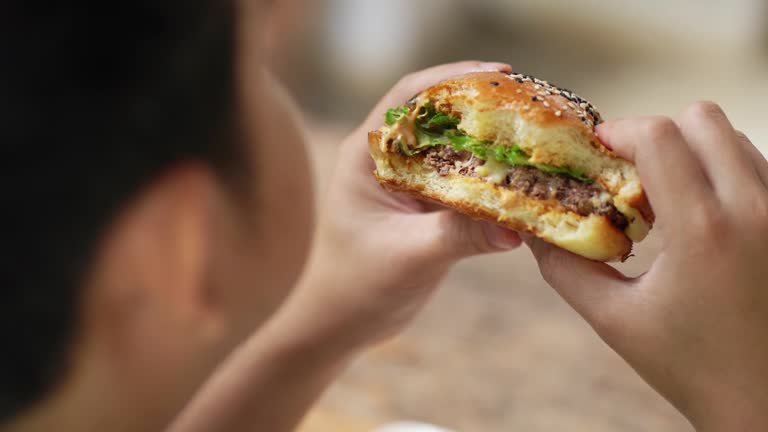 Close up shot men eating hamburgers.