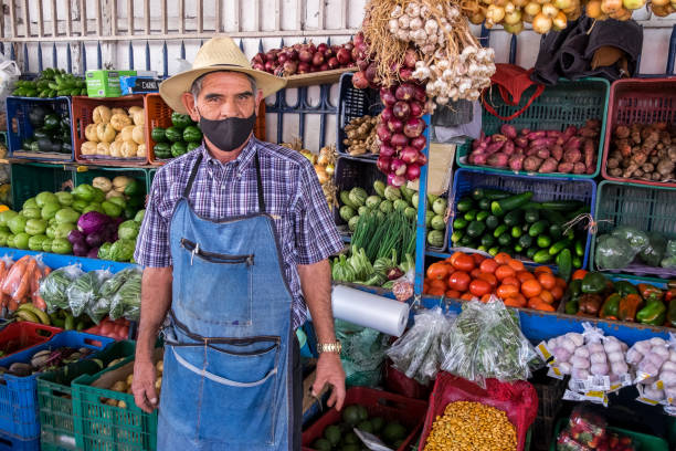 Cartago, Costa Rica - September 16, 2022: Shopkeeper in a stall selling fruit and vegetables in the Municipal Market in the urban center of the city
