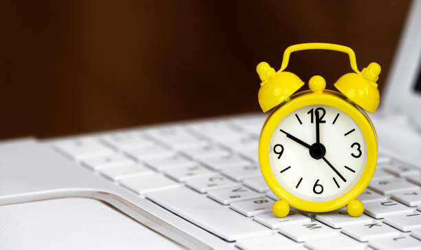 istock Alarm clock on a laptop, daylight savings time banner or background 1430750697