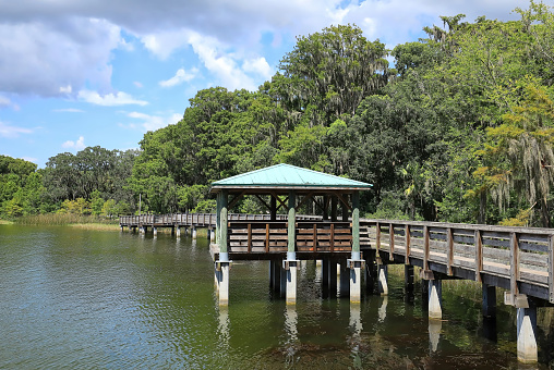 Picnic pavilion and boardwalk at Palm Island Park in Mount Dora, Florida.  Palm Island Park is dog friendly with an 8 acres nature preserve trails and a fishing pier.