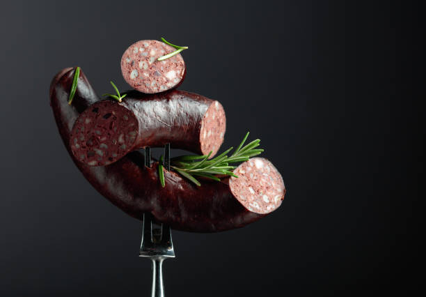 Spanish black pudding or blood sausage with rosemary on a fork. stock photo