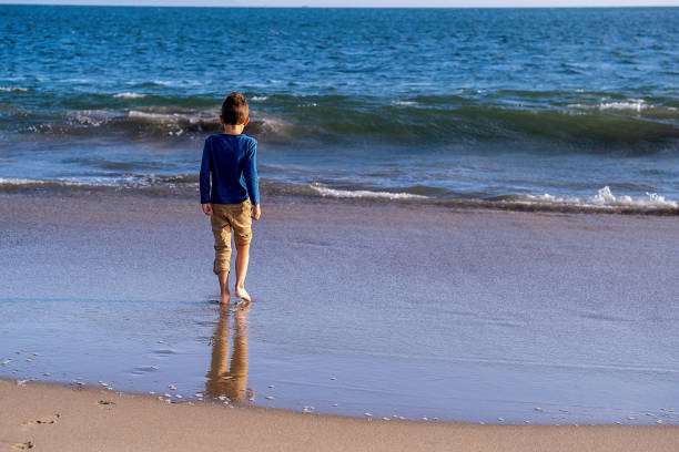 CaucasianLittle boy walking at the beach