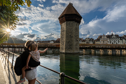 Mother and daughter exploring the beautiful downtown district of Lucerne, which is known for its medieval architecture, and the beautiful Reuss River.