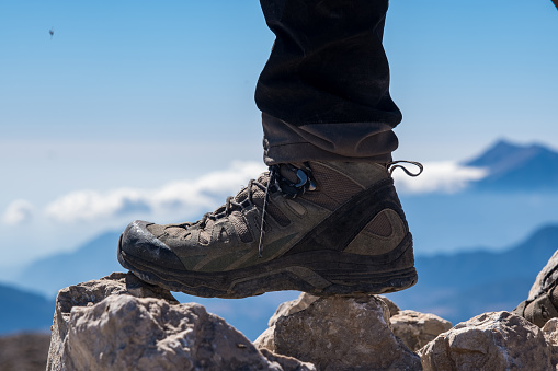 Model's shoes stepping on rocks.Close-up background blur mountain landscape open air.