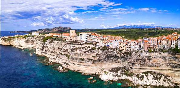 Bonifaccio - splendid coastal town  in south of Corsica island, aerial drone view of houses hanging over rocks. France