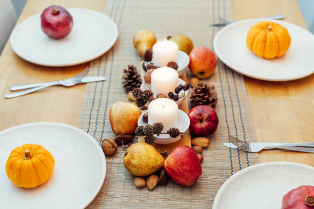 istock Fall table setting for celebration Thanksgiving day family party. Autumn composition with candles, fruits, nuts and cones. Plates with pumpkins and pomegranate. Natural autumn decor. Selective focus 1430767322