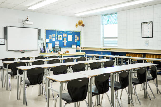 istock Rows of student tables and chairs in a school classroom 1430768701