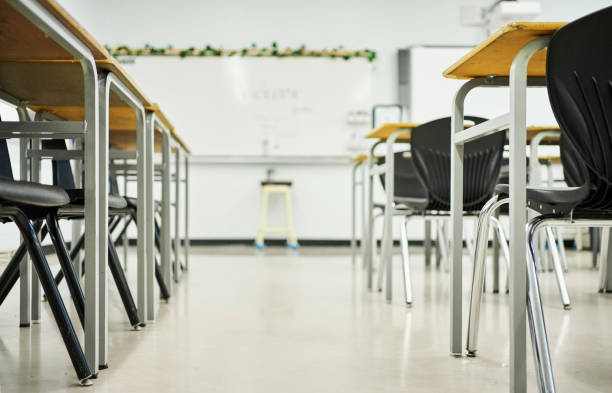 istock Rows of chairs and desks in a school classroom 1430768805