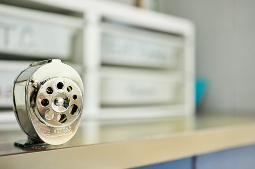 Close-up of a pencil sharpener sitting on a table in a school classroom