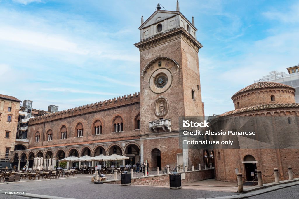 The Square of Erbe in Mantua with historical buildings and a beautiful clock tower Mantua, Italy - 02-26-2022: The Square of Erbe in Mantua with historical buildings and a beautiful clock tower City Stock Photo
