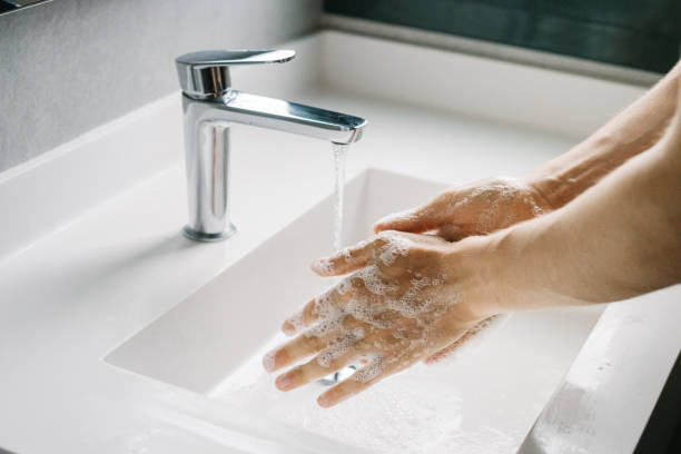 Man washing hands in the bathroom stock photo