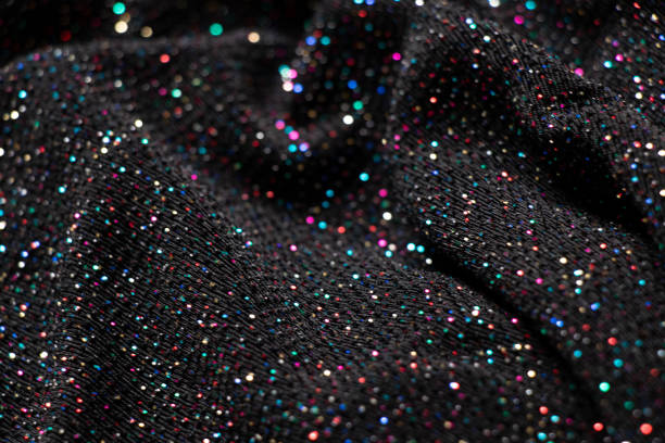 istock black crumpled fabric with multicolored sequins as background, shiny fabric 1430774168