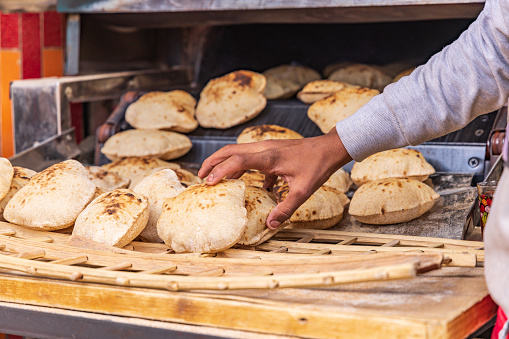 Manshiyat Naser, Garbage City, Cairo, Egypt. Baker making fresh pita bread, known as aish, in Manshiyat Naser, Garbage City, Cairo.