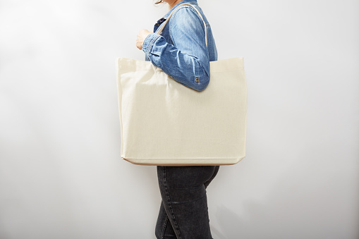 Unrecognizable young woman in denim shirts with a canvas eco tote bag