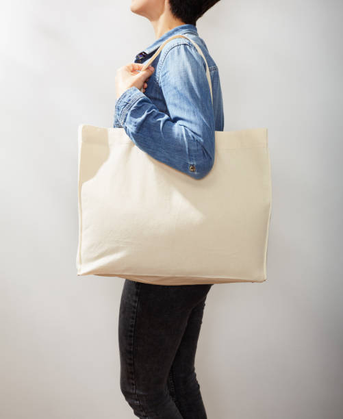 Unrecognizable young woman in denim shirts with a canvas eco tote bag Unrecognizable young woman in denim shirts with a canvas eco tote bag double denim stock pictures, royalty-free photos & images