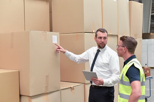 Manager and worker in a warehouse in the logistics sector - transport and processing of orders in trade