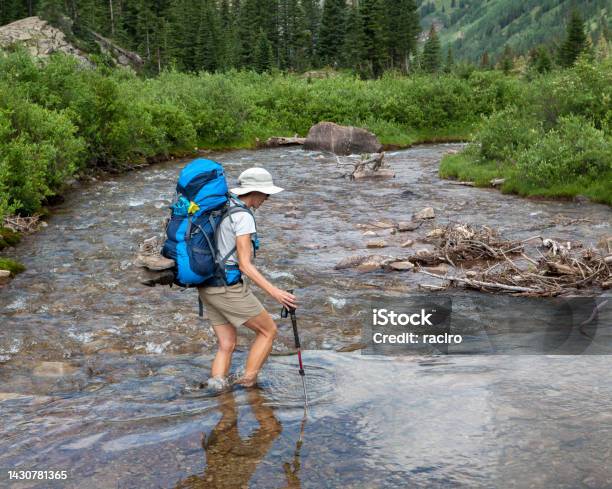 Mature Backpacking Woman Crossing A River Four Pass Backpacking Trip Around The Maroon Bells Aspen Colorado Stock Photo - Download Image Now