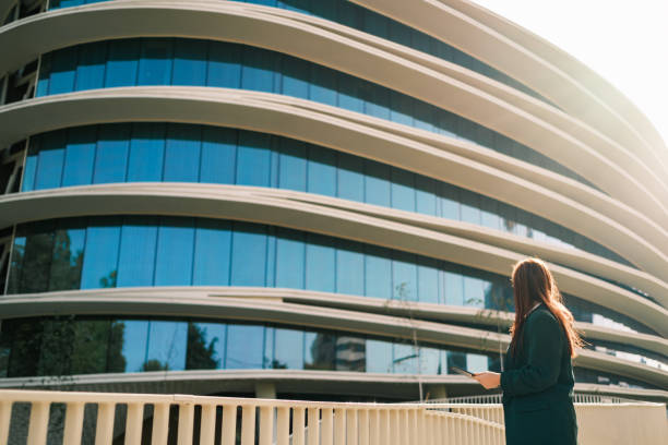 Woman with a tablet in her hand looking at the building
