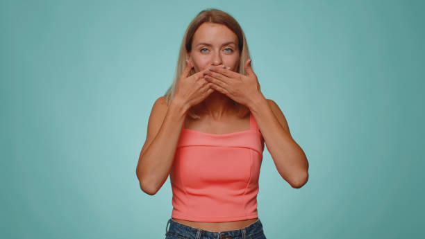 istock Frightened scared young woman closing her mouth gestures no, refusing to tell terrible secret, truth 1430783124