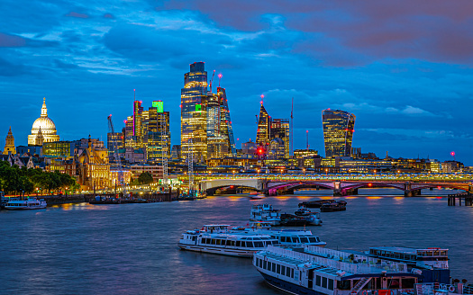 Beleuchtete Skyline des Finanzviertels mit der St Paul's Cathedral in London zur Blauen Stunde am Abend