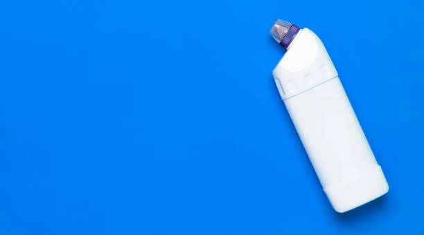 White plastic bottle for liquid detergent, cleaning agent, bleach, antibacterial gel with natural plant extract and green leaves on blue background. Eco style cleaning concept. Flat lay top view. botella de plástico blanco para detergente líquido, agente de limpieza, lejía, gel antibacteriano con extracto natural de plantas y hojas verdes sobre fondo azul. concepto de limpieza de estilo ecológico. vista plana de la parte superior
