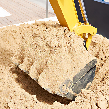 Low angle view of bulldozer on quarry against clear blue sky