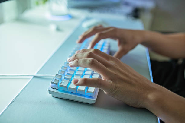 Man Typing on a White Keyboard stock photo