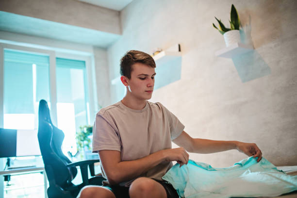 istock Teenager Folding His Clothes 1430797958