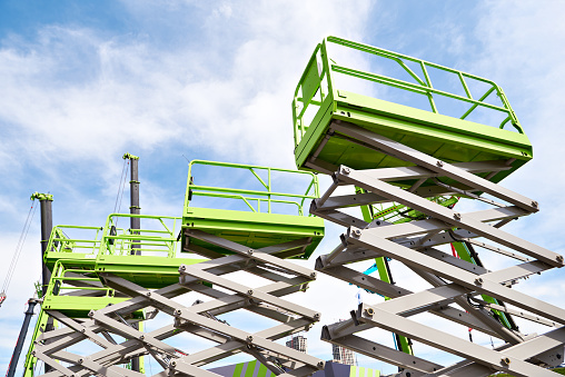 Construction scissor lifts on sky