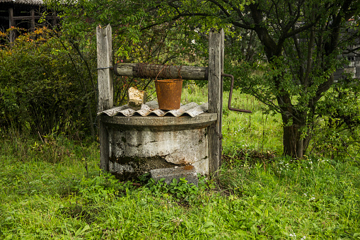 close-up of old draw well and rusty bucket in Ukrainian village