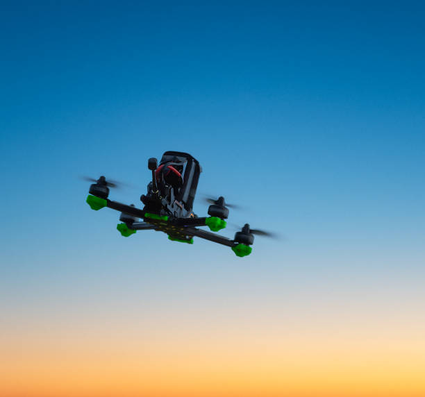 freestyle FPV drone in the sky at sunset, in flight, rear view