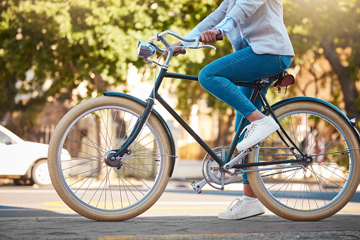 Aventura, viajes por la calle y escapada en bicicleta al aire libre en la ciudad urbana en verano. Mujer con bicicleta vintage en una carretera para el transporte. Persona de sostenibilidad que viaja con mentalidad de salud o energía saludable photo