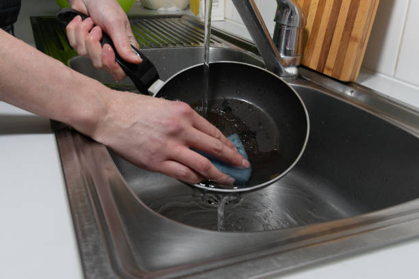 istock washing the pan in the kitchen under running water 1430804187