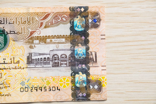 istock Closeup of UAE 200 dirhams currency notes on light wooden table from high angle, paper money 1430804328