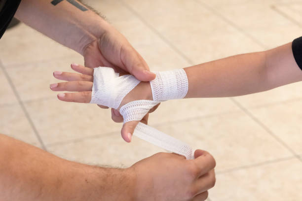 Master applying bandage to child for boxing training