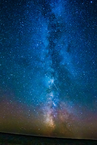Milky Way and shooting star in night sky over the Missouri River in the Charles M. Lewis Wildlife Refuge in northern Montana, western USA.