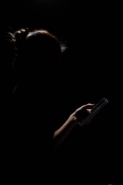 istock Girl in spotlight with cellphone 1430812550