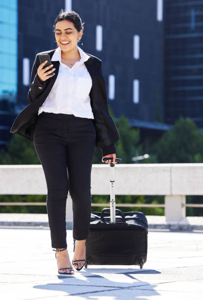istock Business woman, travel with luggage and phone for communication with work, internet or web search. Corporate employee going to airport to catch plane for company tradeshow, conference or workshop 1430812708