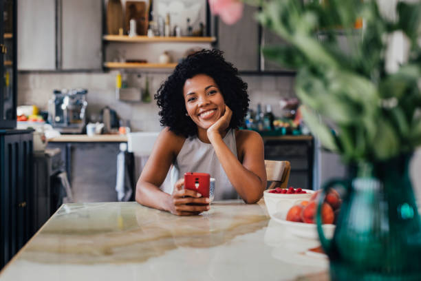 istock A Happy Beautiful Woman Looking At Camera While Using Her Mobile 1430813378