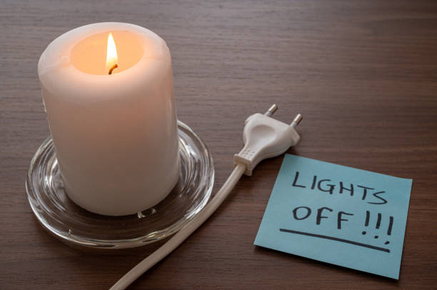 istock Lit candle, electric plug, lights out. 1430813610