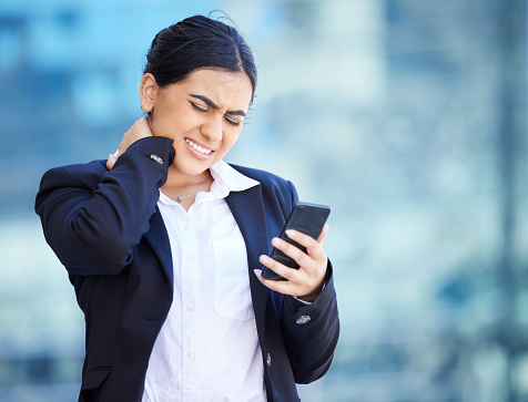 Headache, injury and neck pain while texting, business woman suffering from hurt spine and poor posture. Female entrepreneur holding head while reading a text, upset by bad news or negative feedback