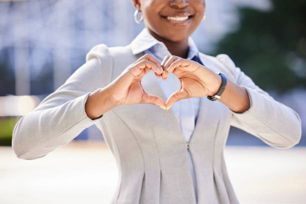 Love and a smile, a business woman makes a heart sign with her hands. Black, corporate office worker and a gesture of respect and friendship with her fingers, happy with work and success in the city Love and a smile, a business woman makes a heart sign with her hands. Black, corporate office worker and a gesture of respect and friendship with her fingers, happy with work and success in the city admiration stock pictures, royalty-free photos & images