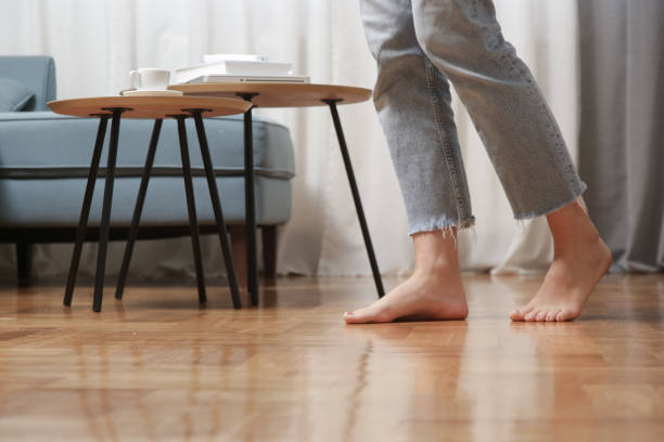 Barefoot woman on the wooden floor. Concept of the underfloor heating in the apartment. stock photo