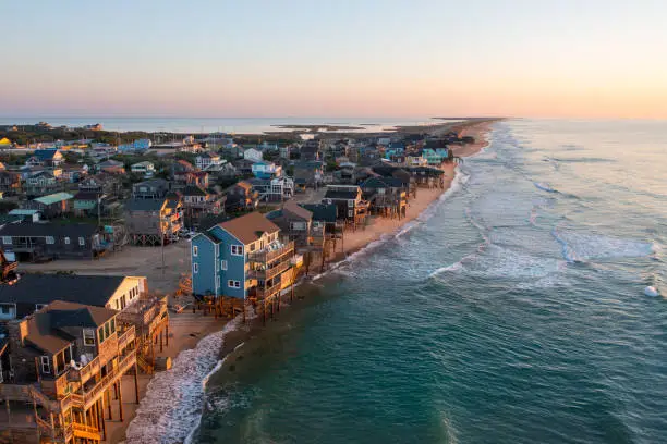 Aerial View of homes right on the shoreline in Buxton North Carolina Hatteras Island at sunrise