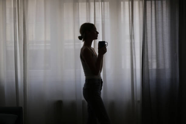 istock Woman drinking coffee next to the window 1430834218