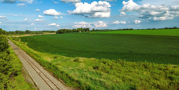 Summertime view of an empty railroad track in the farm fields of Wisconsin