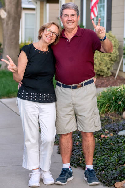 istock Smiling senior couple posing at their home front yard 1430842236