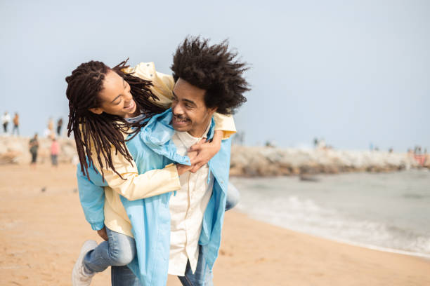 istock Happy Afro couple having fun on the beach and taking a selfie 1430845047
