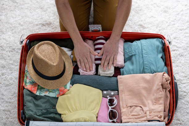 istock Woman hands packing suitcase for summer vacation journey, top view 1430846168